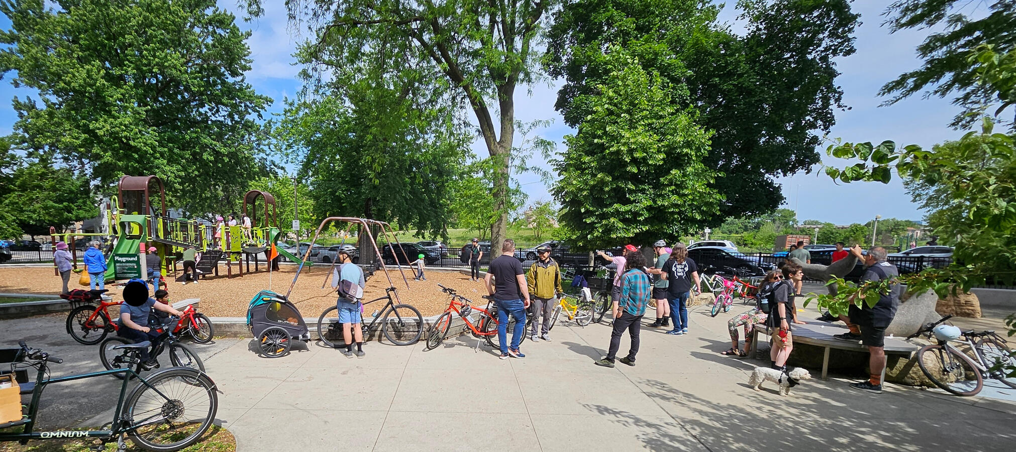 Untitled adults with kids and their bikes in a park.