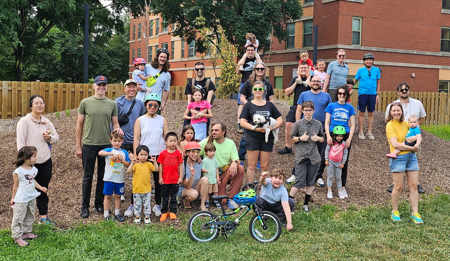 A few dozen people on a mulch pile with a bike up front. A few dozen people on a mulch pile with a bike up front.
